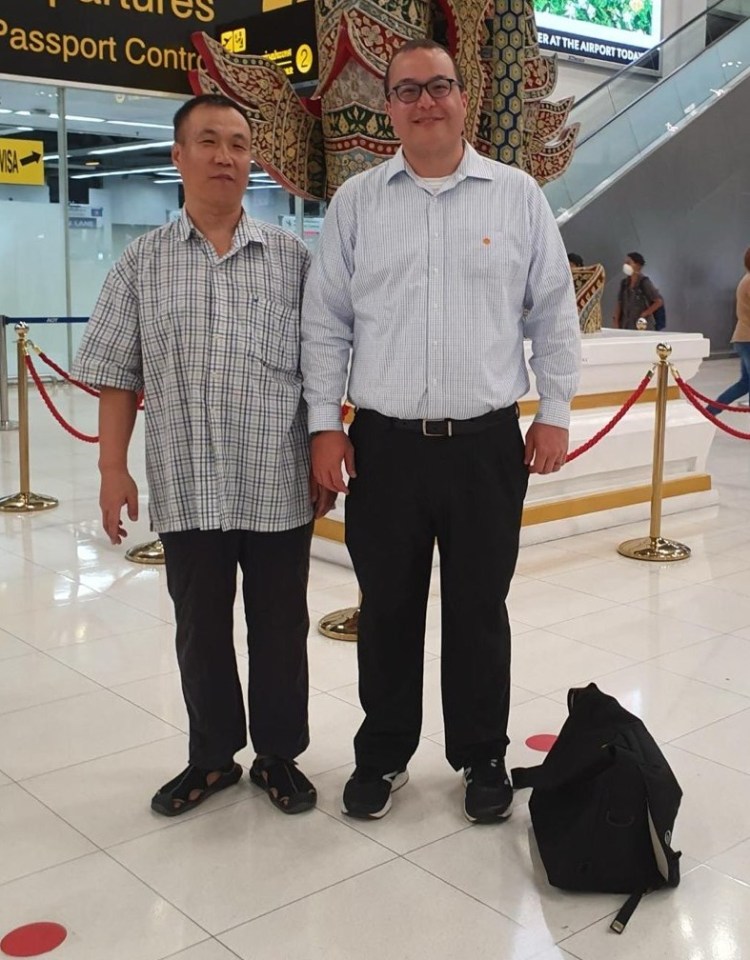 two men standing in front of a sign that says passport control