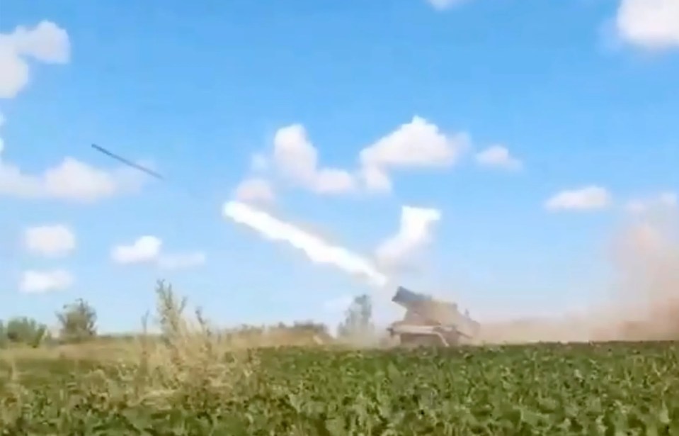 a rocket is being launched from a tank in a field .
