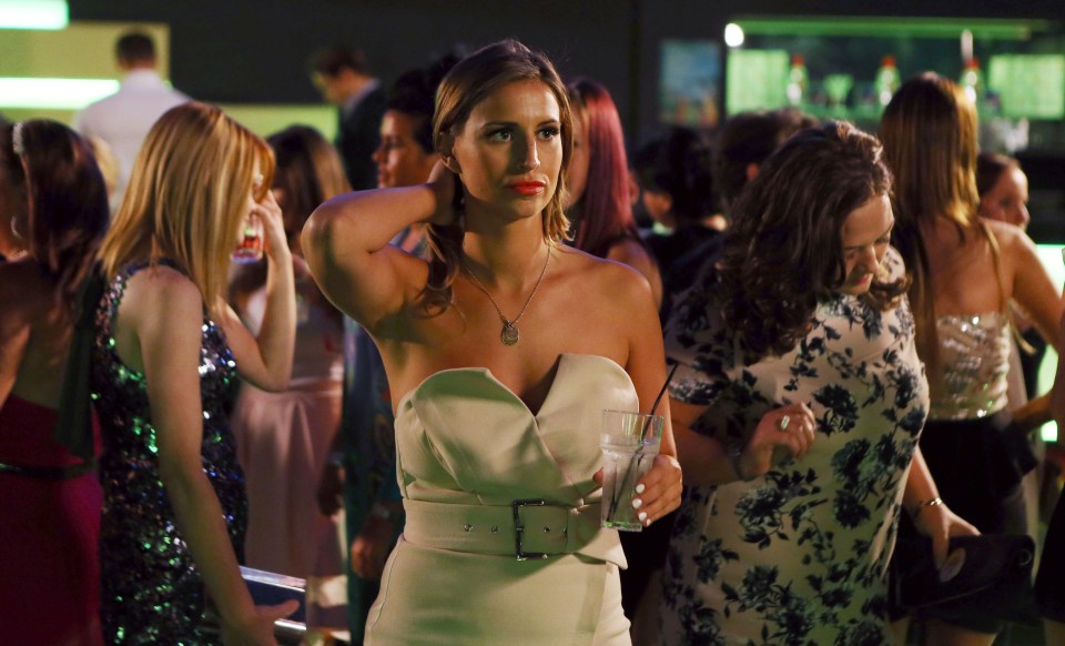 a woman in a white dress stands in a crowd of people