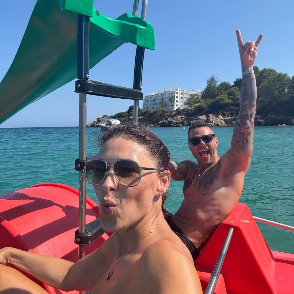 a man and a woman are on a red boat in the ocean