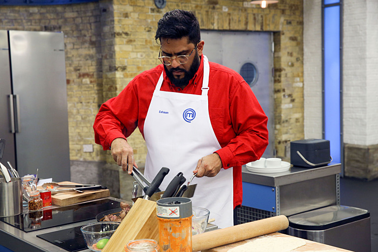a man wearing an apron with the letter m on it