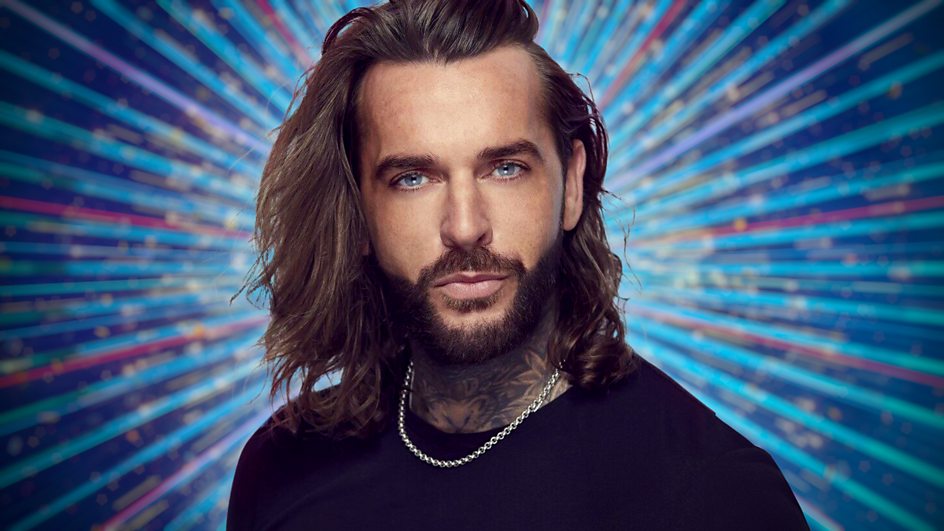 a man with long hair and a beard wearing a black shirt