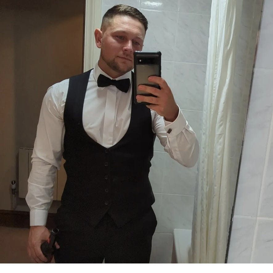 a man in a tuxedo is taking a picture of himself in the mirror