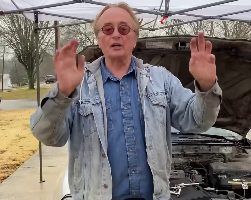 a man standing in front of a car with a license plate that says cb71704