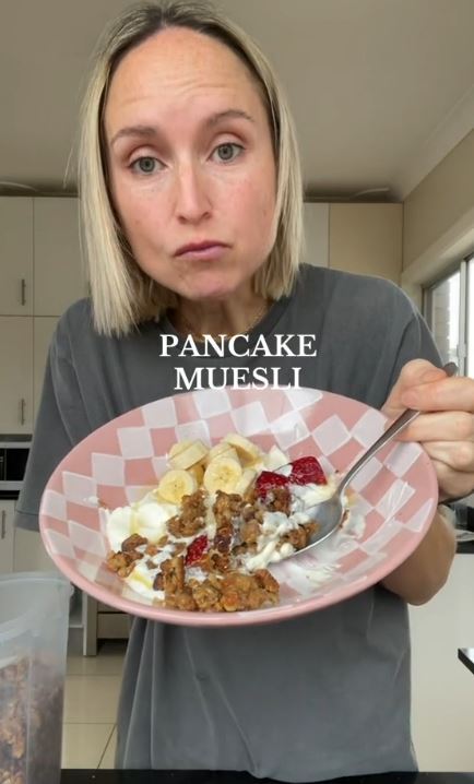 a woman is holding a plate of pancake muesli