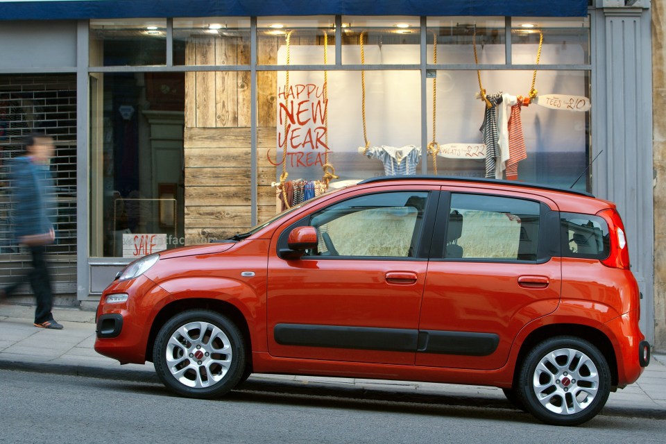 a red car is parked in front of a store that says happy new year treat
