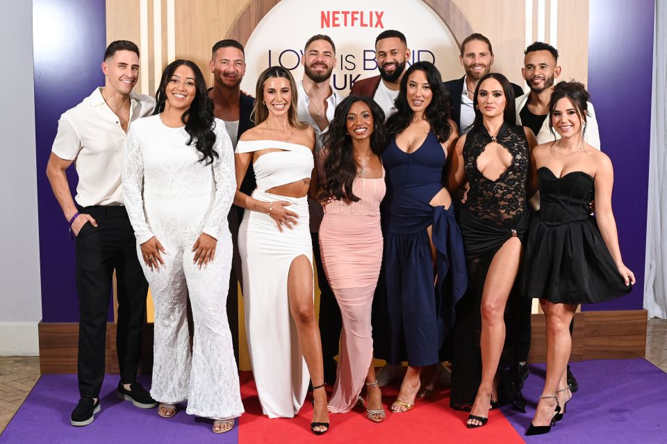 a group of people standing on a red carpet in front of a sign that says netflix