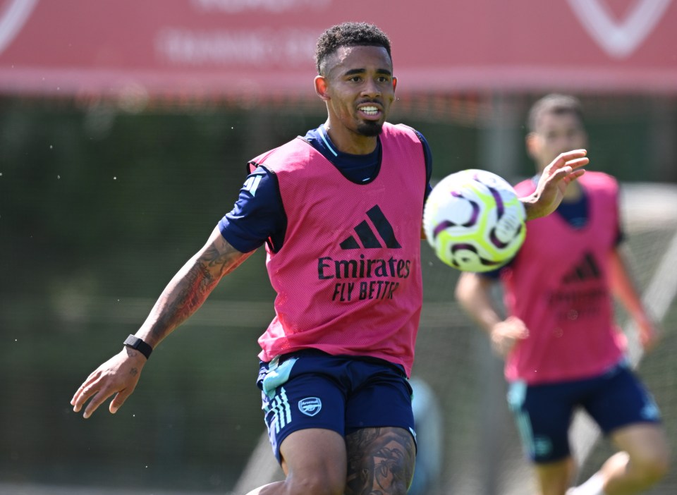soccer player wearing a pink vest that says emirates fly better