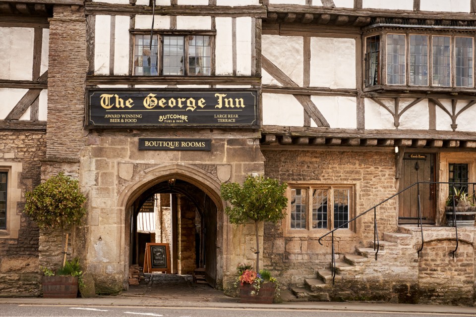 the entrance to the george inn has a sign that says boutique rooms