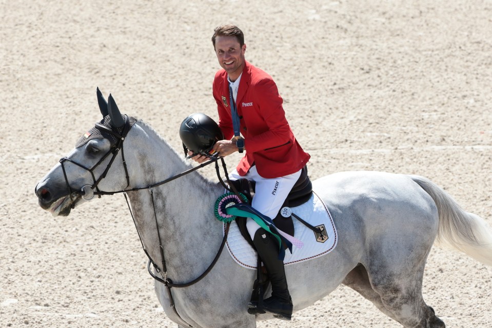 a man in a red jacket is riding a horse