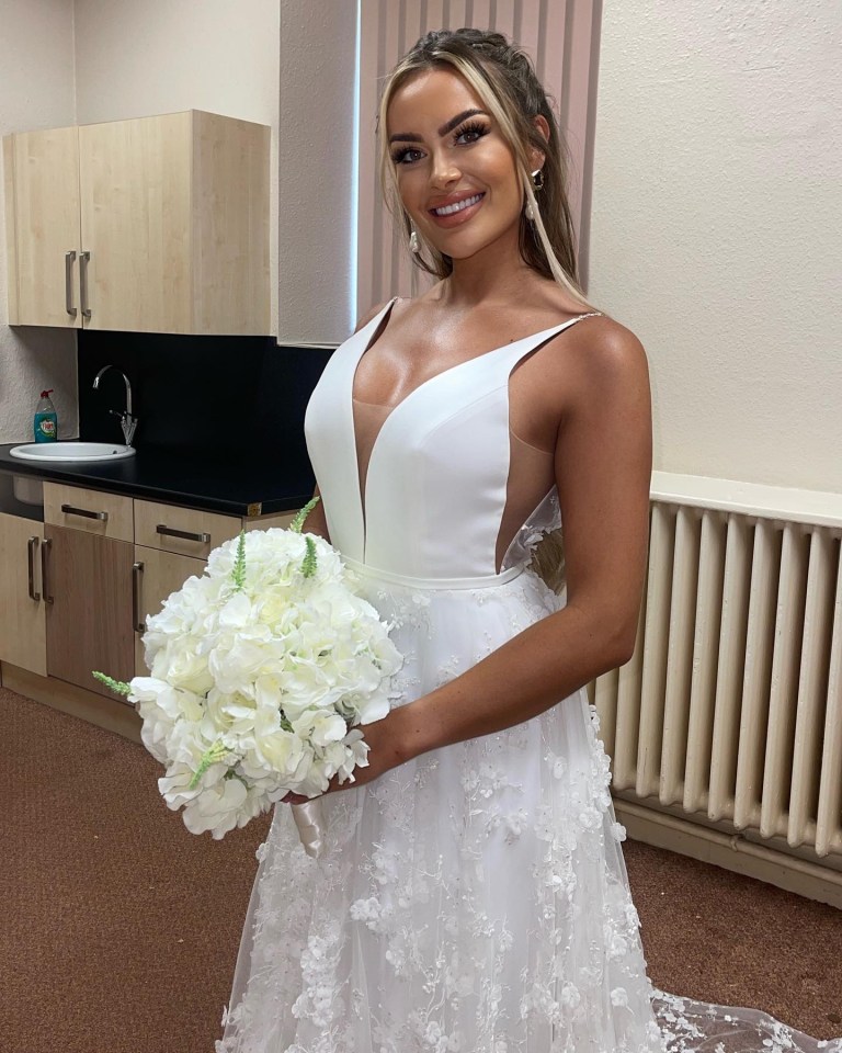 a woman in a white dress holds a bouquet of white flowers