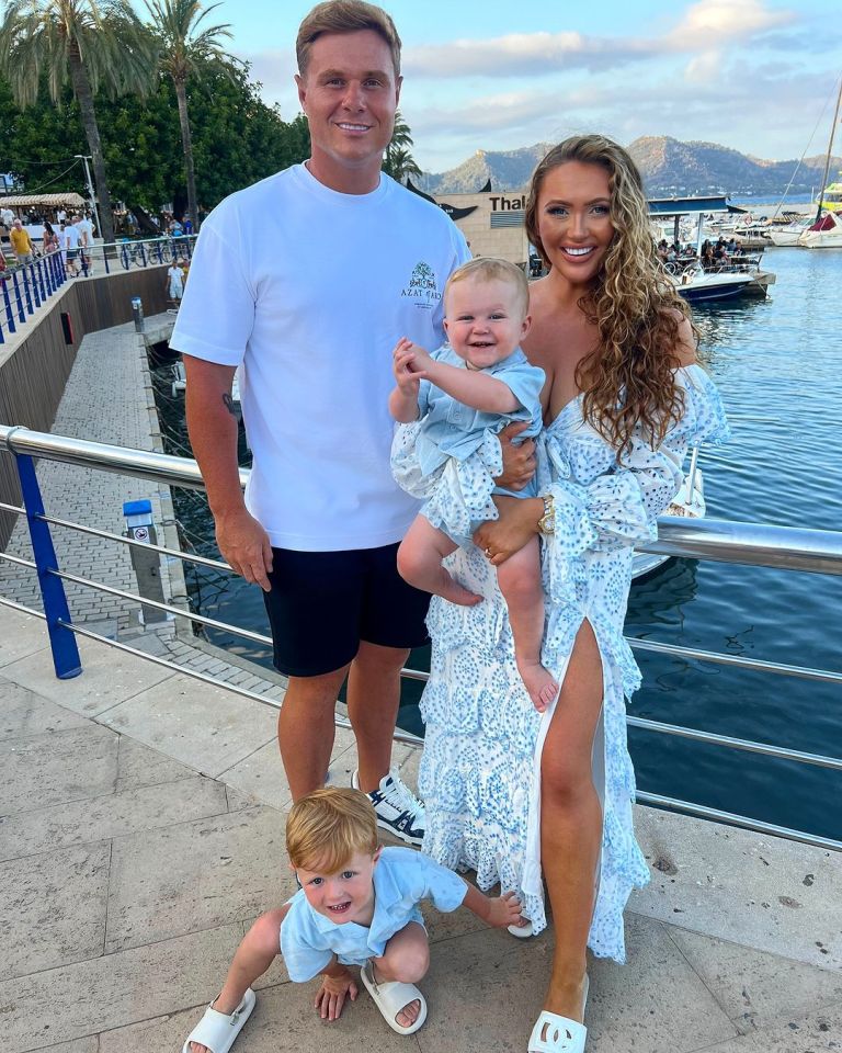 a family posing for a picture in front of a body of water