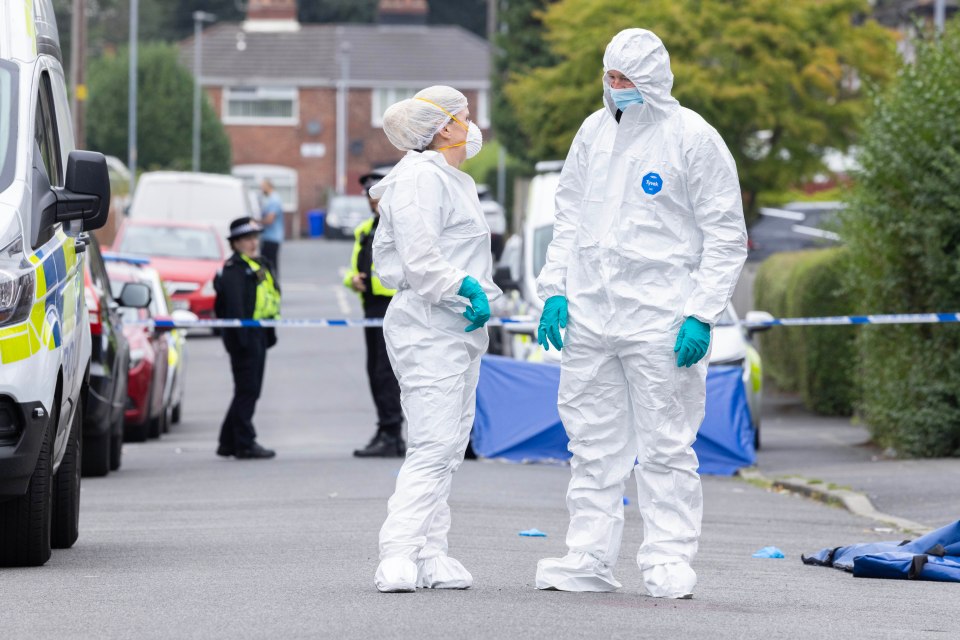 a man and a woman in protective suits are standing on a street