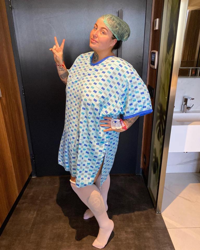 a woman in a hospital gown giving a peace sign