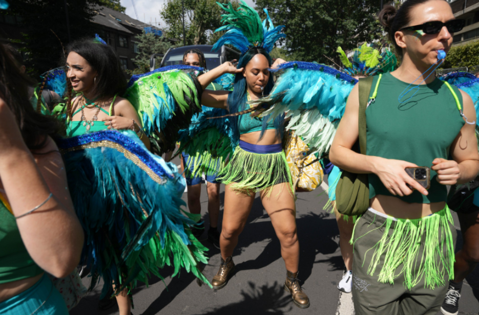 a group of people dressed in green and blue feathered costumes