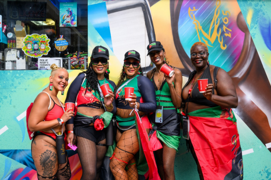 a group of women standing in front of a sign that says pick up your favorite drinks here