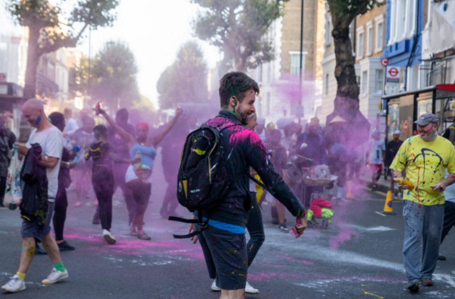 a man with a backpack stands in front of a crowd of people