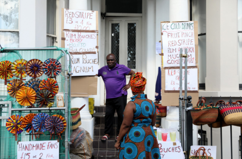 a man in a purple shirt stands in front of a sign that says " red stripe "