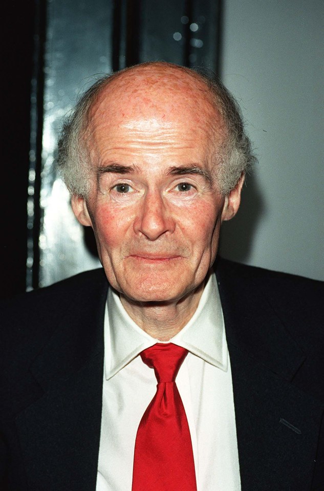 a man in a suit and red tie looks at the camera