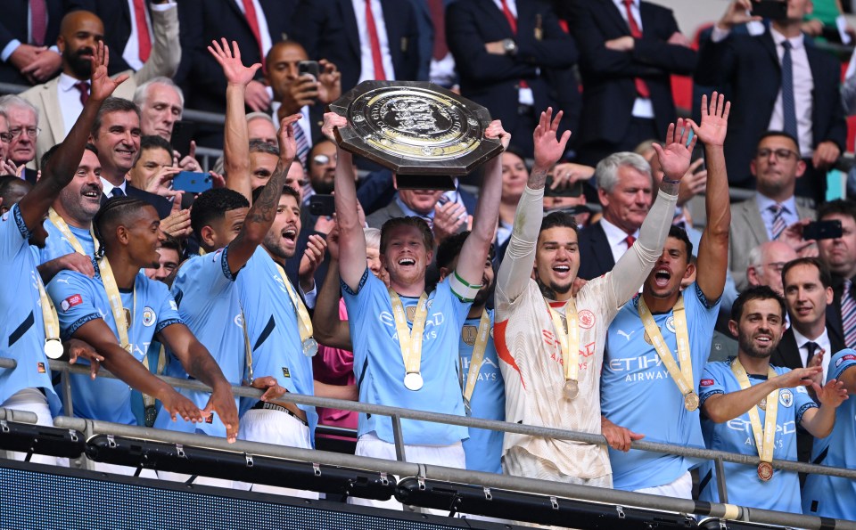 a group of soccer players holding up a trophy that says etihad airways