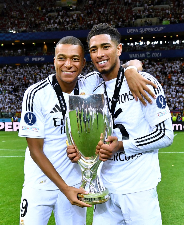 two soccer players holding a trophy that says competition on it