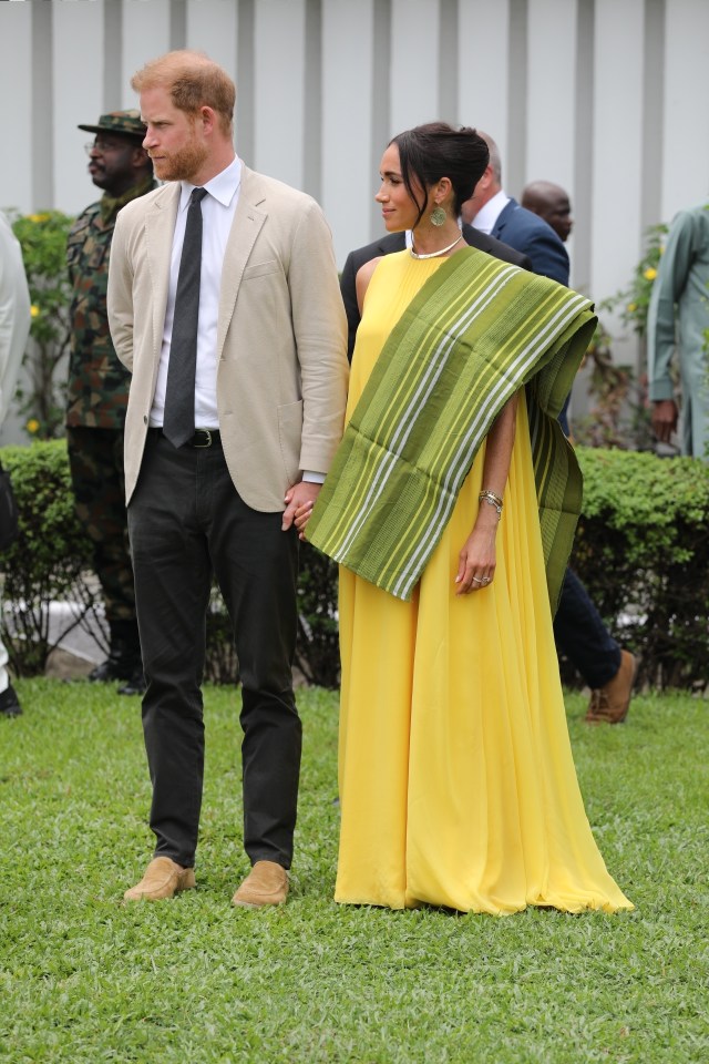 a man in a suit and tie stands next to a woman in a yellow dress