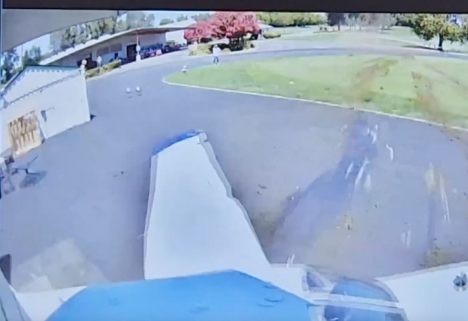 a computer screen shows a driveway with a white building in the background