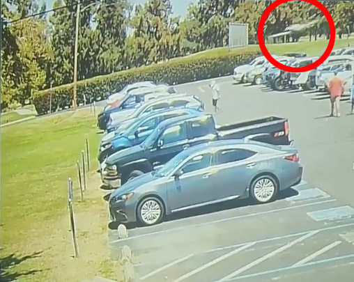 a gray car is parked in a parking lot with a red circle around it