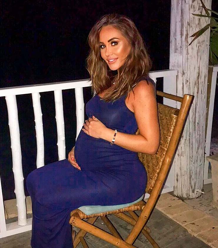 a pregnant woman in a blue dress is sitting in a chair