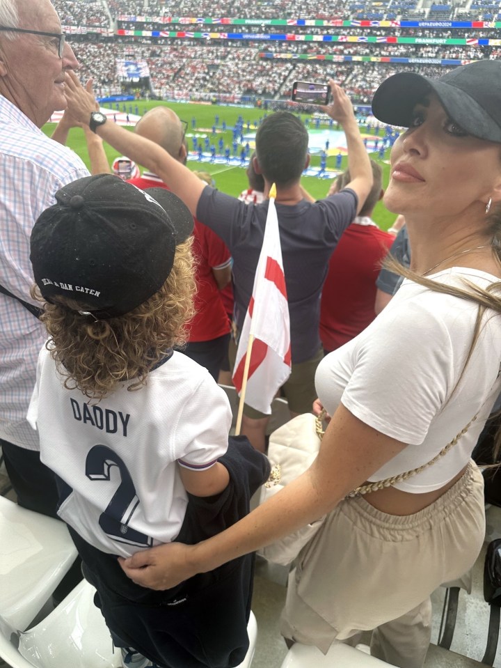 a little boy wearing a white jersey that says daddy