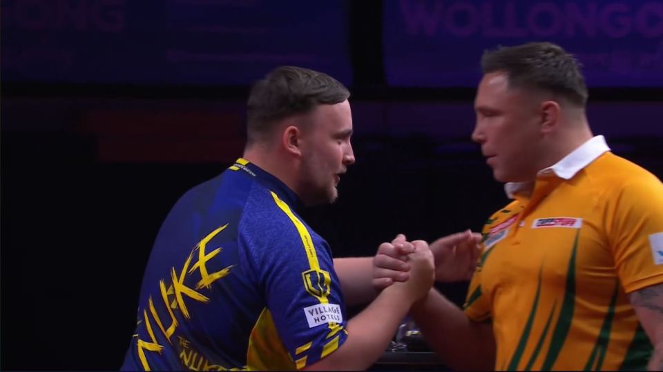 two men shake hands in front of a sign that says wollongong