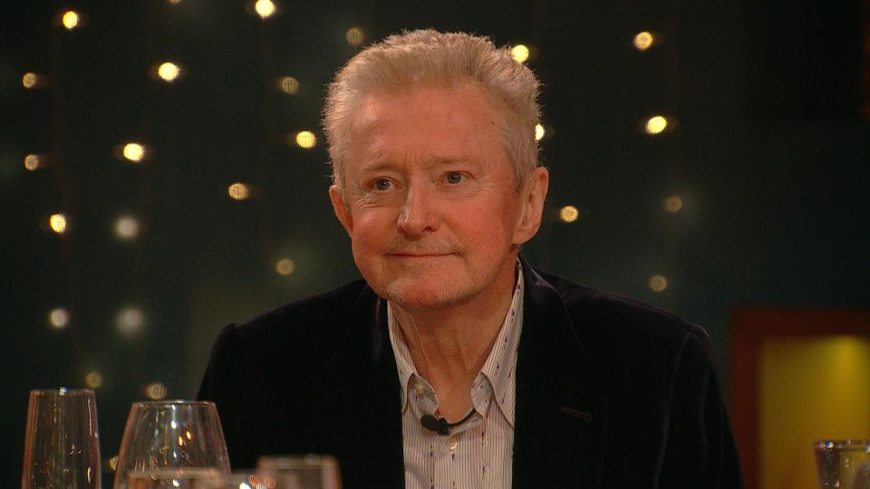 a man sitting at a table with a microphone in his jacket