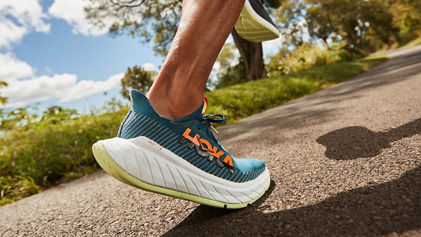a person is running on a road wearing a pair of hoka one one running shoes .
