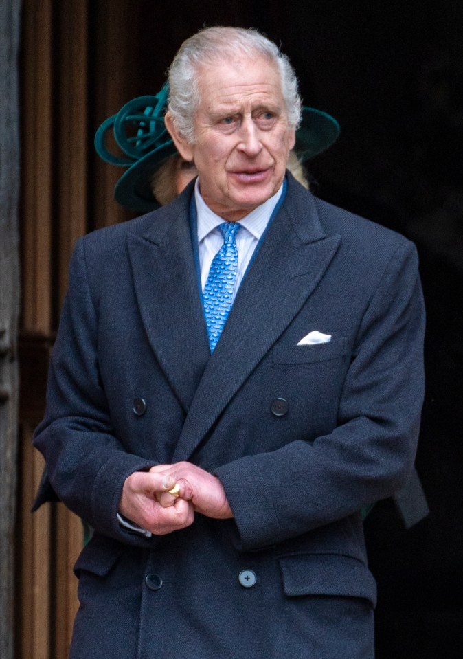 a man in a suit and tie with a woman in a green hat behind him