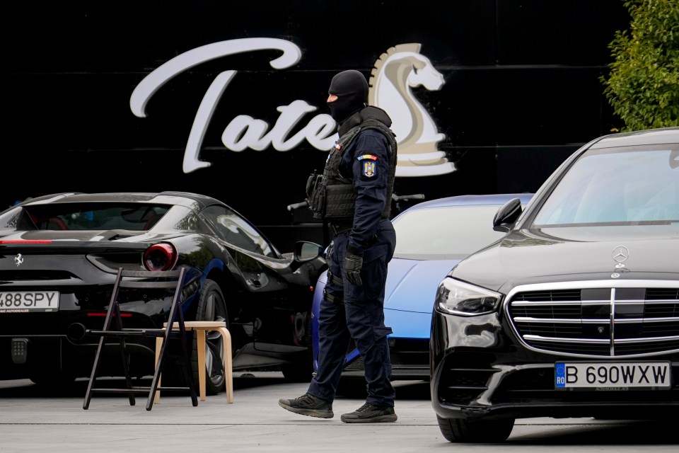 a man in a mask stands in front of a sign that says tate