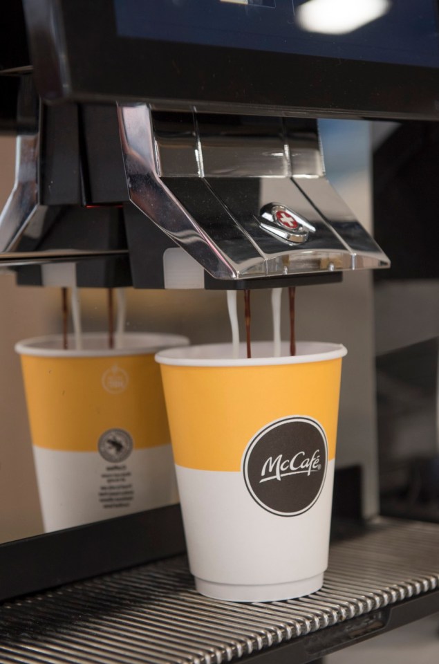 two cups of mccafe are being poured into a machine
