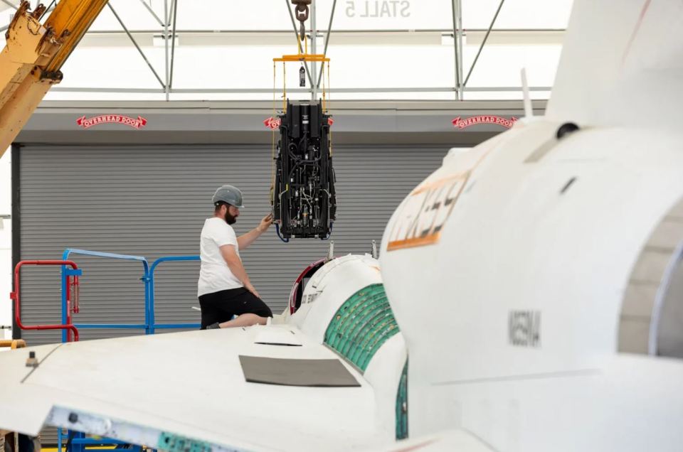 a man is working on a plane in a hangar that has a sign that says ' keller ' on it