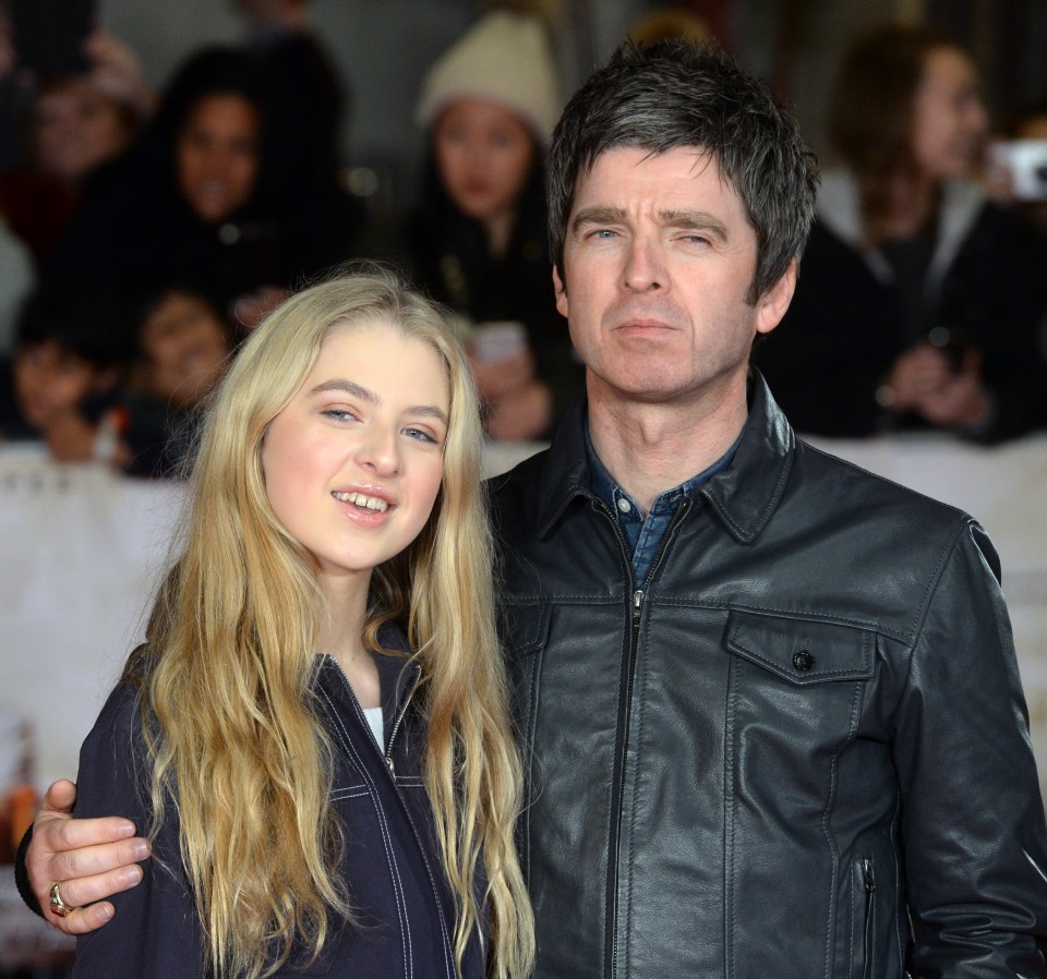 a man in a leather jacket stands next to a young girl