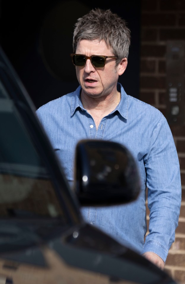 a man wearing sunglasses is standing in front of a car