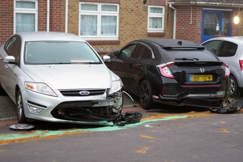 a silver ford car is parked next to a black honda civic