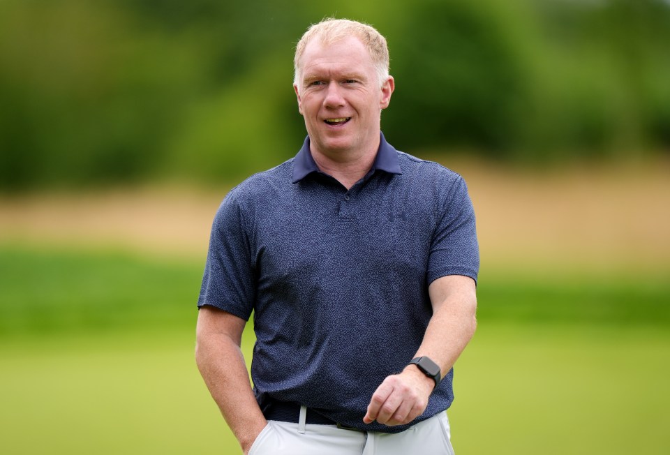 a man in a blue shirt is standing on a golf course