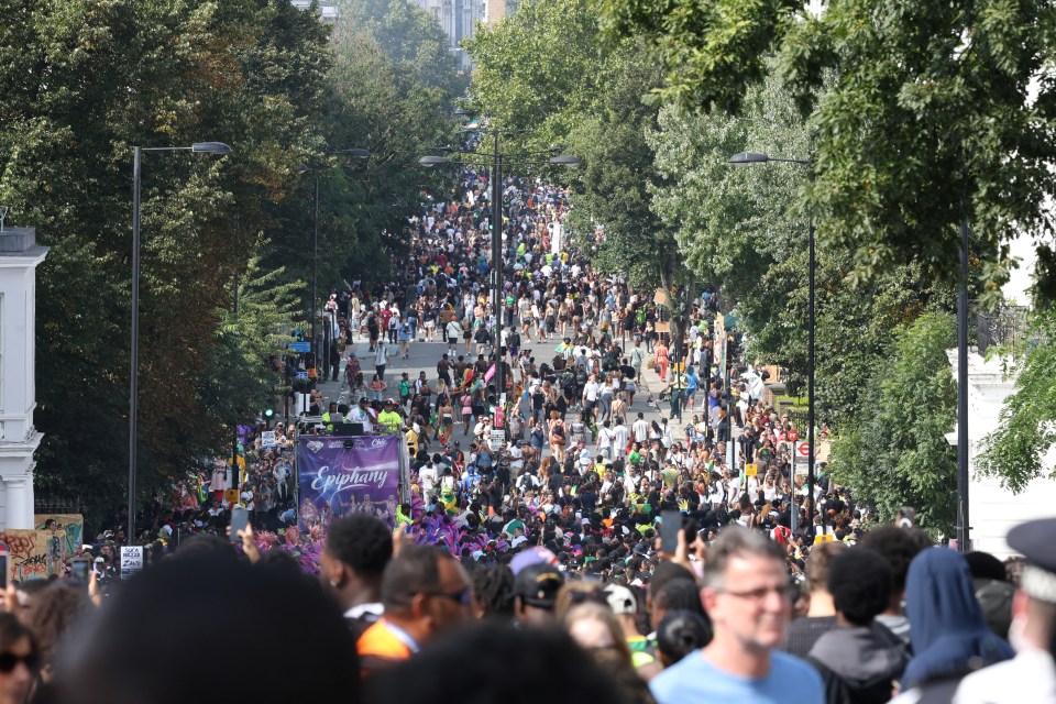 a large crowd of people are gathered on a street with a carlsberg sign in the background