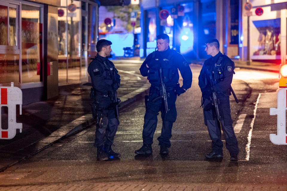 a group of police officers standing on a street with one wearing a badge that says ' polizei ' on it