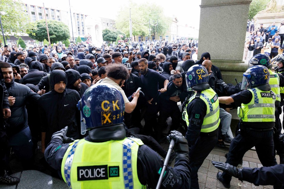 Counter-demonstrators push against a police cordon in Bolton