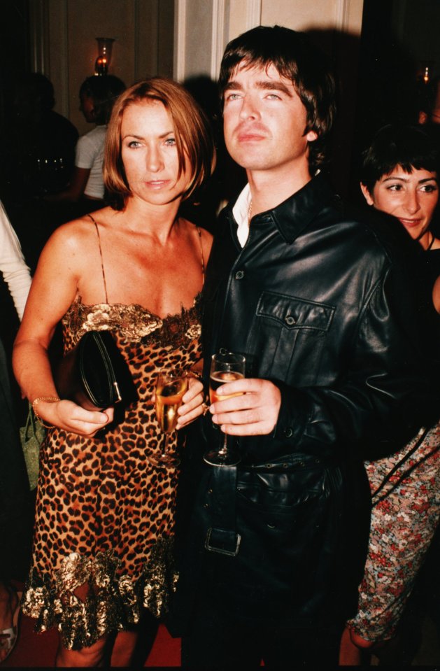 a man in a leather jacket stands next to a woman in a leopard print dress
