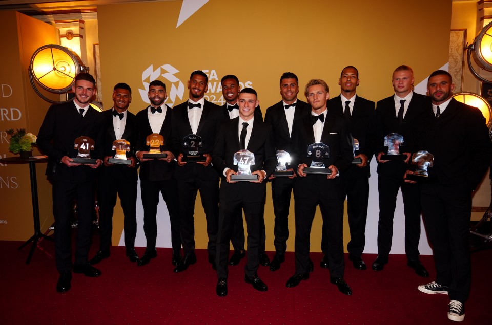 a group of men holding trophies in front of a wall that says awards