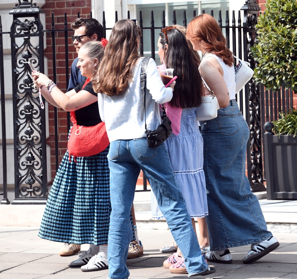 a woman taking a picture of a group of people