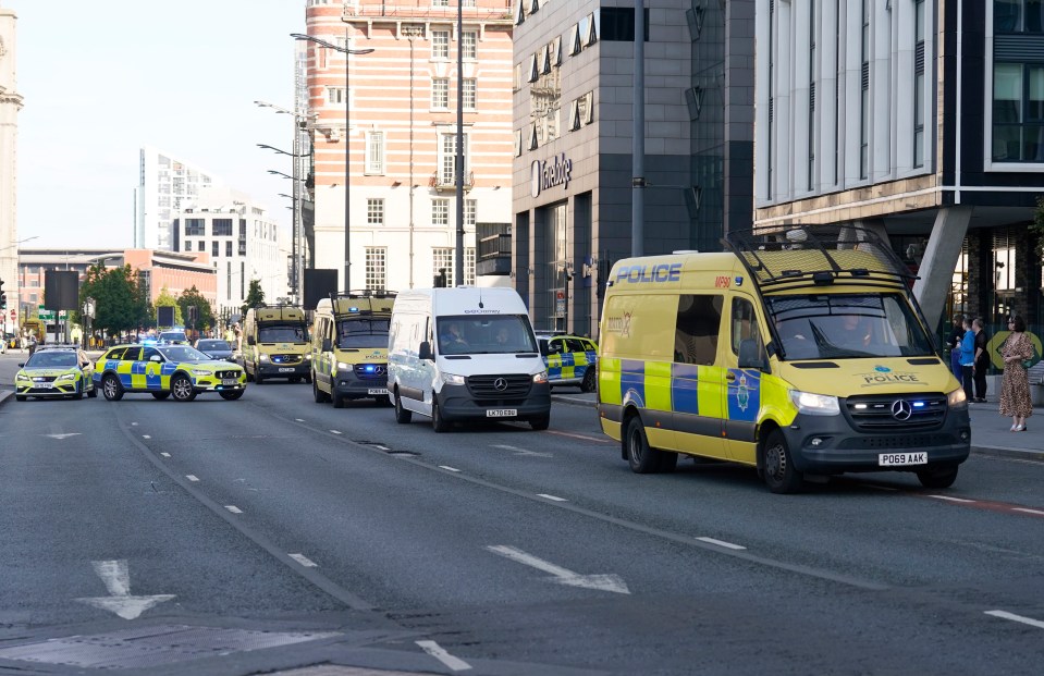 a yellow and white police van is driving down the street