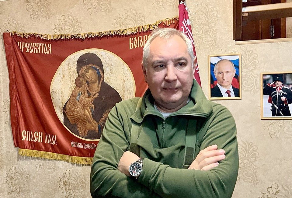 a man with his arms crossed in front of a red banner that says ' slash ' on it