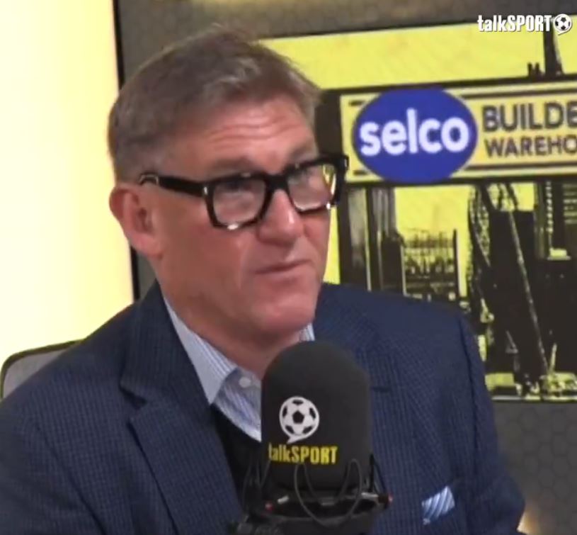 a man wearing glasses talks into a talksport microphone